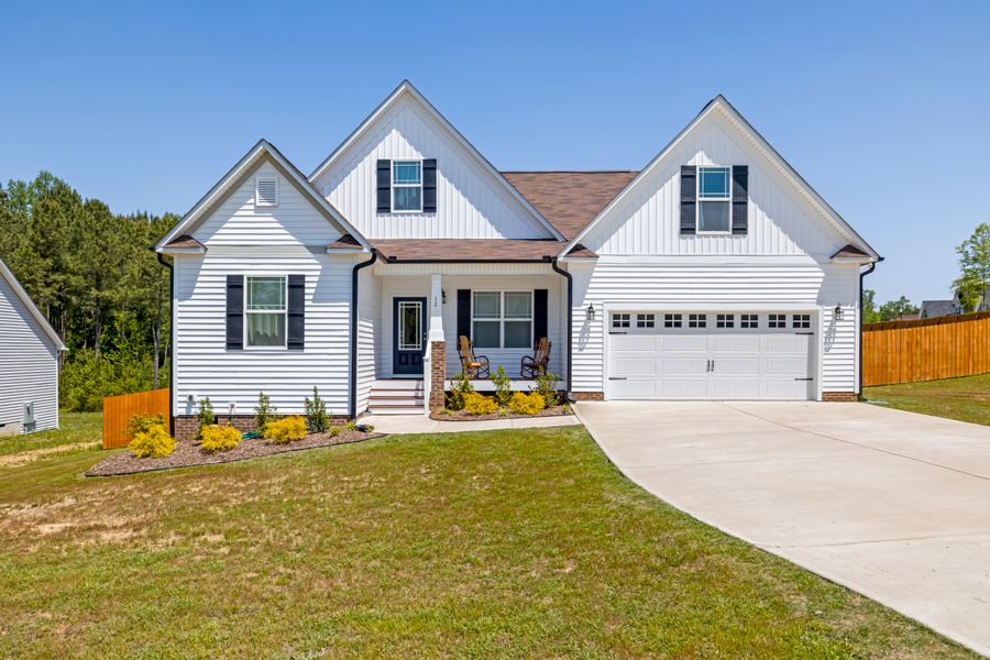 A suburban home with a small porch and rocking chairs